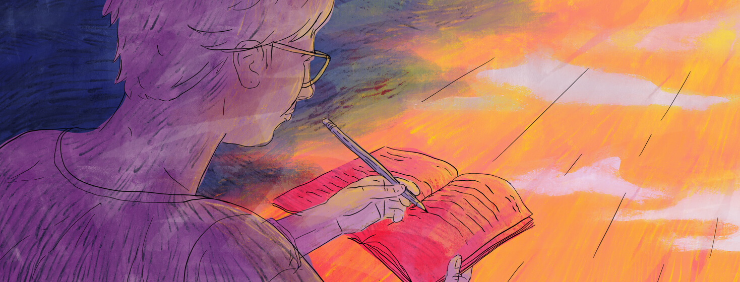 A person is writing in a journal while the sun is rising in the background.