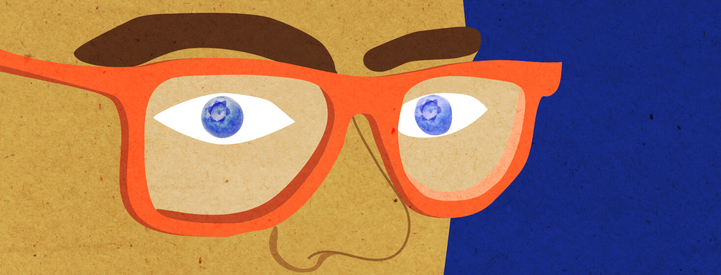 A close up of a person wearing orange glasses. There are blueberries in their eye instead of pupils.